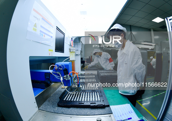 Workers rush to make computer and tablet battery orders at a workshop in Hai'an, China, on September 11, 2024. 