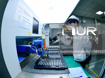 Workers rush to make computer and tablet battery orders at a workshop in Hai'an, China, on September 11, 2024. (