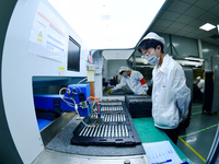 Workers rush to make computer and tablet battery orders at a workshop in Hai'an, China, on September 11, 2024. (