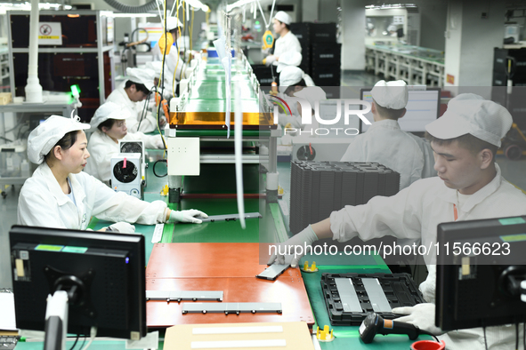 Workers rush to make computer and tablet battery orders at a workshop in Hai'an, China, on September 11, 2024. 