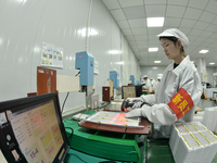 Workers rush to make computer and tablet battery orders at a workshop in Hai'an, China, on September 11, 2024. (