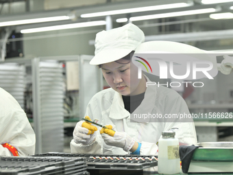 Workers rush to make computer and tablet battery orders at a workshop in Hai'an, China, on September 11, 2024. (