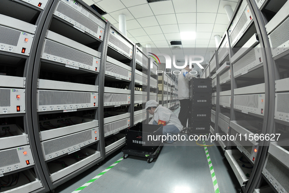 Workers rush to make computer and tablet battery orders at a workshop in Hai'an, China, on September 11, 2024. 