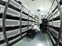 Workers rush to make computer and tablet battery orders at a workshop in Hai'an, China, on September 11, 2024. (