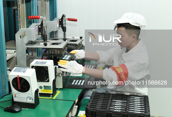 Workers rush to make computer and tablet battery orders at a workshop in Hai'an, China, on September 11, 2024. 