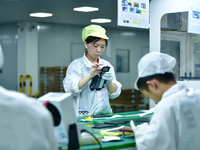 Workers rush to make computer and tablet battery orders at a workshop in Hai'an, China, on September 11, 2024. (