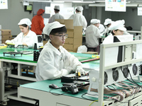 Workers rush to make computer and tablet battery orders at a workshop in Hai'an, China, on September 11, 2024. (