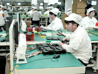 Workers rush to make computer and tablet battery orders at a workshop in Hai'an, China, on September 11, 2024. (