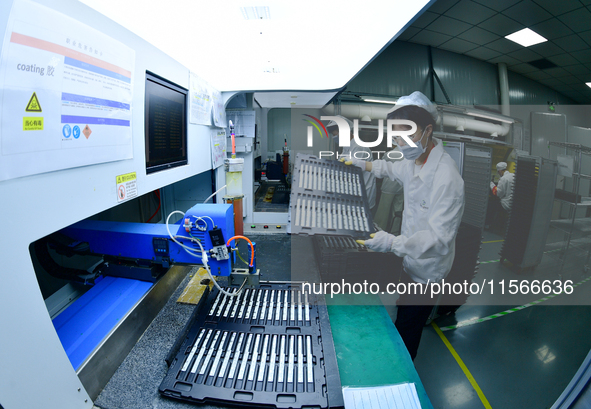 Workers rush to make computer and tablet battery orders at a workshop in Hai'an, China, on September 11, 2024. 