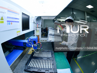 Workers rush to make computer and tablet battery orders at a workshop in Hai'an, China, on September 11, 2024. (