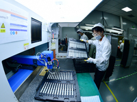 Workers rush to make computer and tablet battery orders at a workshop in Hai'an, China, on September 11, 2024. (