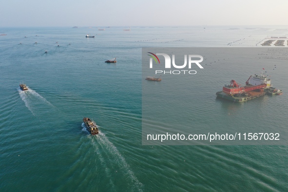 Workers work in a breeding area at a marine ranch in Dinghai Bay, Lianjiang County in Fuzhou, China, on September 10, 2024. 