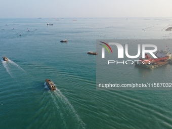 Workers work in a breeding area at a marine ranch in Dinghai Bay, Lianjiang County in Fuzhou, China, on September 10, 2024. (