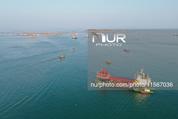 Workers work in a breeding area at a marine ranch in Dinghai Bay, Lianjiang County in Fuzhou, China, on September 10, 2024. 