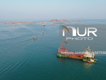 Workers work in a breeding area at a marine ranch in Dinghai Bay, Lianjiang County in Fuzhou, China, on September 10, 2024. (