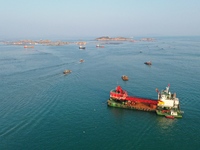 Workers work in a breeding area at a marine ranch in Dinghai Bay, Lianjiang County in Fuzhou, China, on September 10, 2024. (