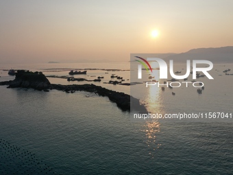 Workers work in a breeding area at a marine ranch in Dinghai Bay, Lianjiang County in Fuzhou, China, on September 10, 2024. (