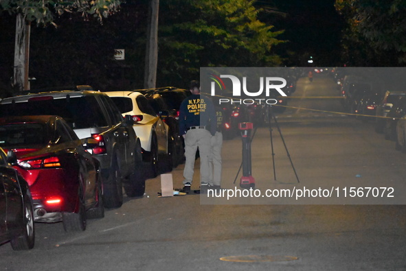 Crime scene investigators collect evidence at the scene where a man is killed by a shot to the head in Queens, New York, on September 11, 20...