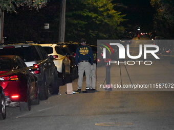 Crime scene investigators collect evidence at the scene where a man is killed by a shot to the head in Queens, New York, on September 11, 20...