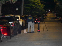 Crime scene investigators collect evidence at the scene where a man is killed by a shot to the head in Queens, New York, on September 11, 20...