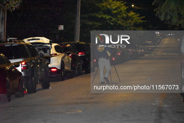 Crime scene investigators collect evidence at the scene where a man is killed by a shot to the head in Queens, New York, on September 11, 20...