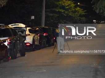 Crime scene investigators collect evidence at the scene where a man is killed by a shot to the head in Queens, New York, on September 11, 20...