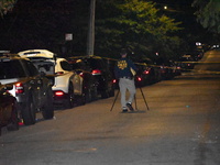 Crime scene investigators collect evidence at the scene where a man is killed by a shot to the head in Queens, New York, on September 11, 20...