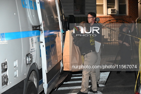 Crime scene investigators collect evidence at the scene where a man is killed by a shot to the head in Queens, New York, on September 11, 20...