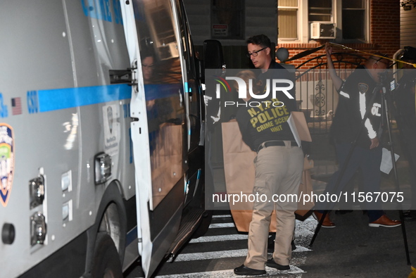 Crime scene investigators collect evidence at the scene where a man is killed by a shot to the head in Queens, New York, on September 11, 20...