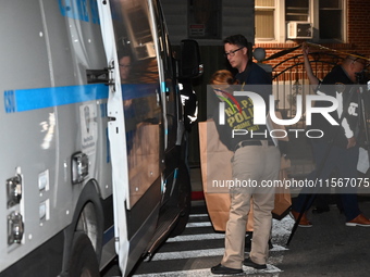 Crime scene investigators collect evidence at the scene where a man is killed by a shot to the head in Queens, New York, on September 11, 20...