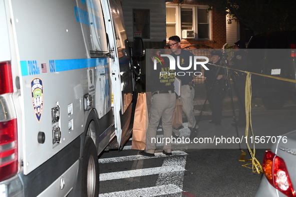 Crime scene investigators collect evidence at the scene where a man is killed by a shot to the head in Queens, New York, on September 11, 20...