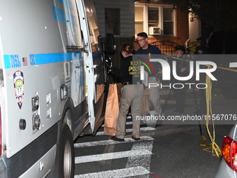 Crime scene investigators collect evidence at the scene where a man is killed by a shot to the head in Queens, New York, on September 11, 20...