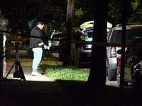 Crime scene investigators collect evidence at the scene where a man is killed by a shot to the head in Queens, New York, on September 11, 20...