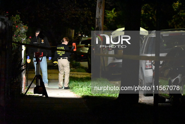 Crime scene investigators collect evidence at the scene where a man is killed by a shot to the head in Queens, New York, on September 11, 20...