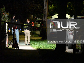 Crime scene investigators collect evidence at the scene where a man is killed by a shot to the head in Queens, New York, on September 11, 20...