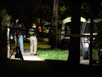 Crime scene investigators collect evidence at the scene where a man is killed by a shot to the head in Queens, New York, on September 11, 20...