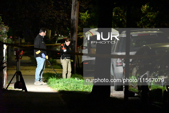 Crime scene investigators collect evidence at the scene where a man is killed by a shot to the head in Queens, New York, on September 11, 20...