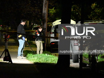 Crime scene investigators collect evidence at the scene where a man is killed by a shot to the head in Queens, New York, on September 11, 20...