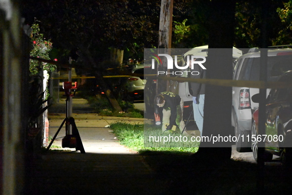 Crime scene investigators collect evidence at the scene where a man is killed by a shot to the head in Queens, New York, on September 11, 20...