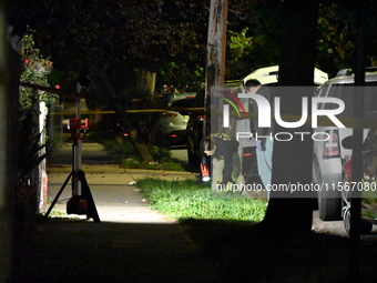 Crime scene investigators collect evidence at the scene where a man is killed by a shot to the head in Queens, New York, on September 11, 20...