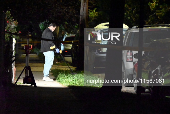 Crime scene investigators collect evidence at the scene where a man is killed by a shot to the head in Queens, New York, on September 11, 20...