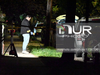 Crime scene investigators collect evidence at the scene where a man is killed by a shot to the head in Queens, New York, on September 11, 20...