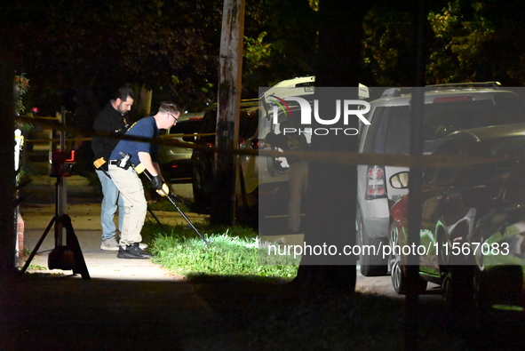 Crime scene investigators collect evidence at the scene where a man is killed by a shot to the head in Queens, New York, on September 11, 20...