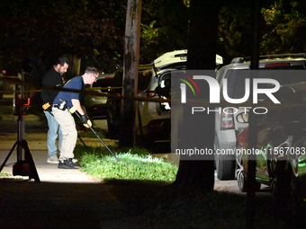 Crime scene investigators collect evidence at the scene where a man is killed by a shot to the head in Queens, New York, on September 11, 20...