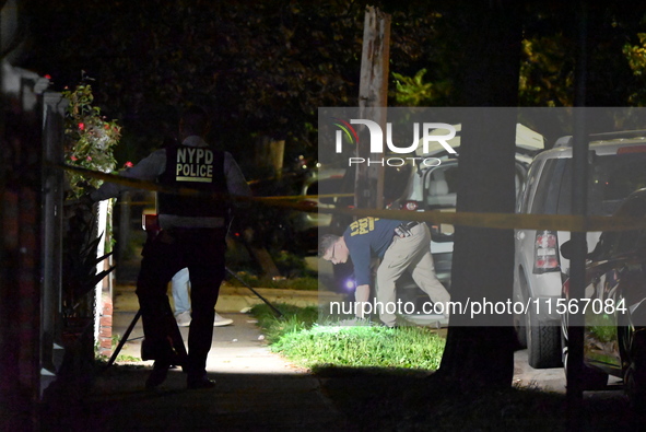 Crime scene investigators collect evidence at the scene where a man is killed by a shot to the head in Queens, New York, on September 11, 20...