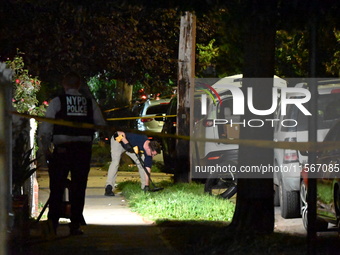 Crime scene investigators collect evidence at the scene where a man is killed by a shot to the head in Queens, New York, on September 11, 20...