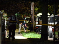 Crime scene investigators collect evidence at the scene where a man is killed by a shot to the head in Queens, New York, on September 11, 20...