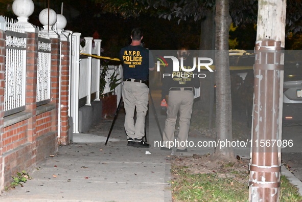 Crime scene investigators collect evidence at the scene where a man is killed by a shot to the head in Queens, New York, on September 11, 20...