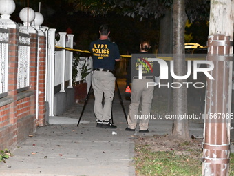 Crime scene investigators collect evidence at the scene where a man is killed by a shot to the head in Queens, New York, on September 11, 20...