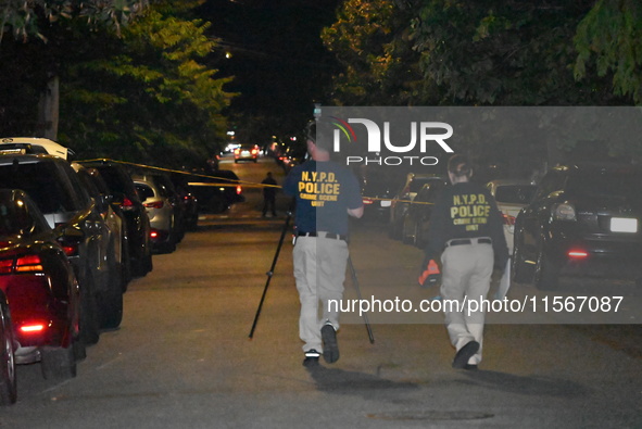 Crime scene investigators collect evidence at the scene where a man is killed by a shot to the head in Queens, New York, on September 11, 20...